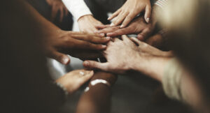 Hände die zusammengehen, Team, warme Farben braun, Konfliktmanagement