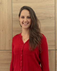 Stefanie Hengstler, rote Bluse, Hintergrund Holzwand, Projektmanagerin
