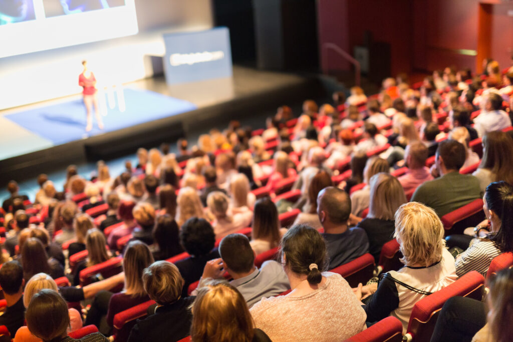 Keynote Speaker Stage Academy, Saal, Publikum, Zuhörer, Rote Stühle, Leinwand