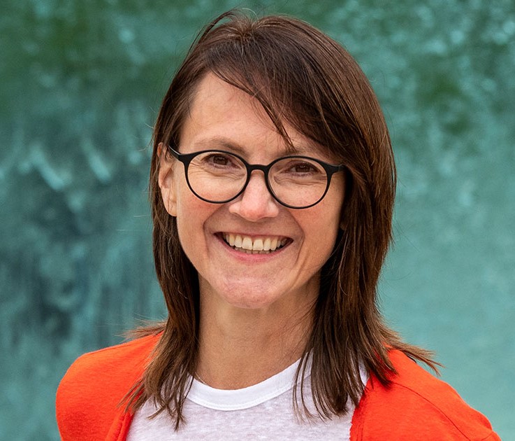 Gerlinde Michel, Frau, lächelnd, Braune und lange Haare, orange Jacke, weißes T-Shirt